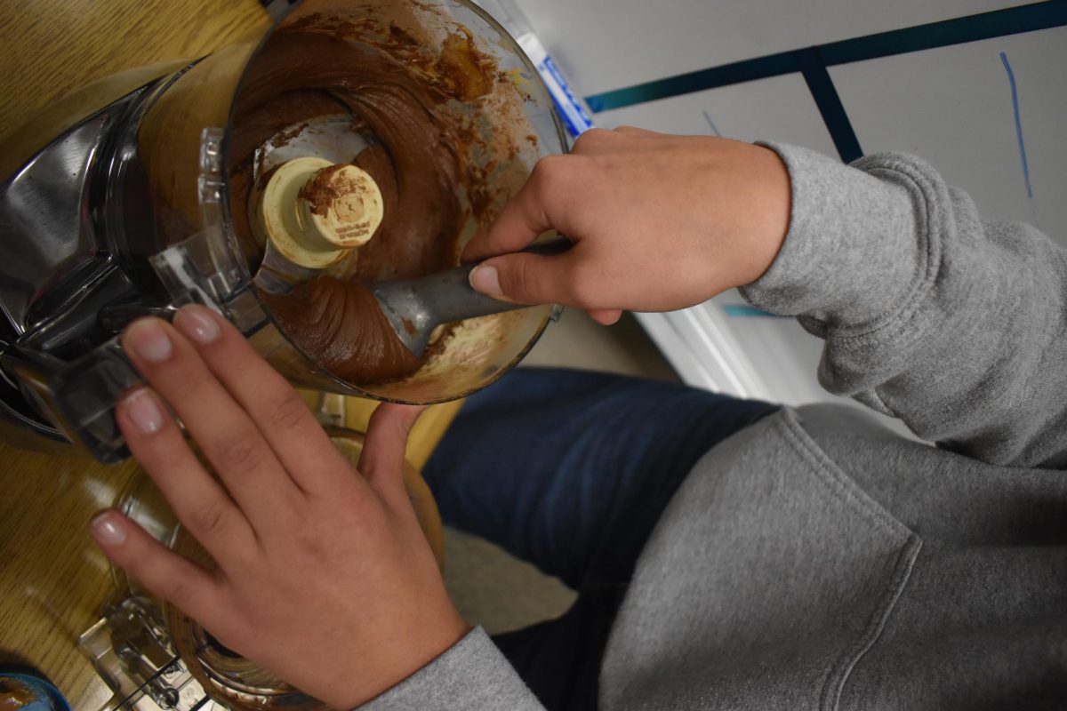 The process of mixing together the peanut butter, honey and cocoa powder with only a food processor.